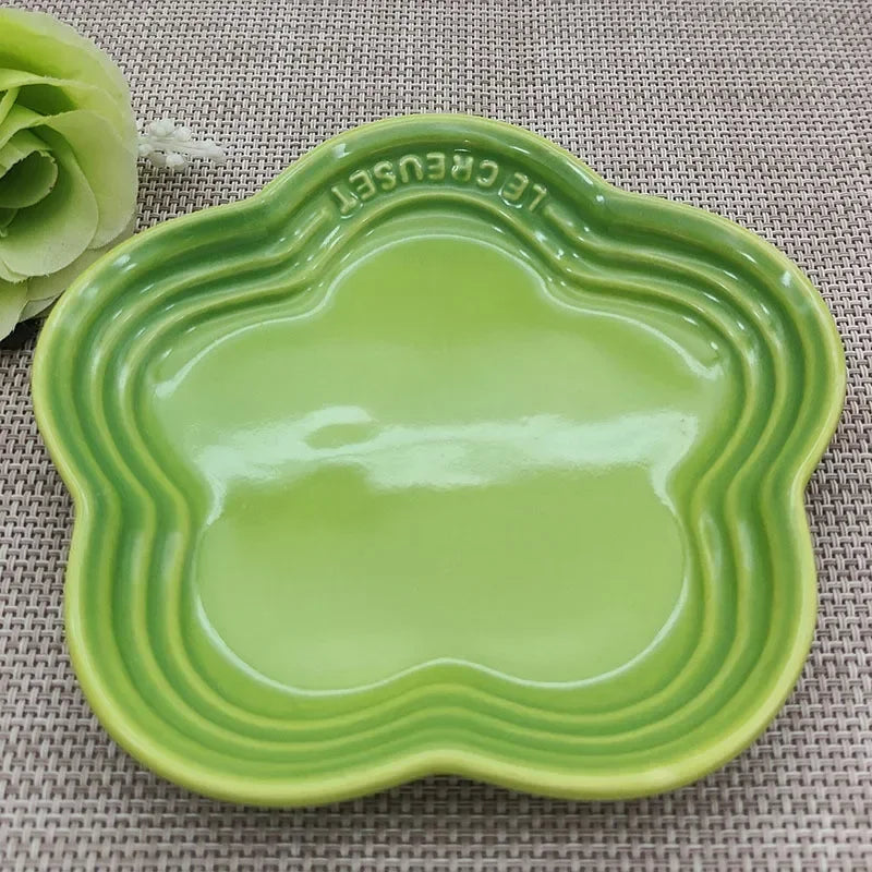Green ceramic paw-shaped whisker friendly cat bowl by Paw Care USA on a textured surface