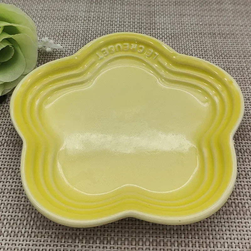 Yellow paw-shaped whisker friendly cat bowl by Paw Care USA on woven placemat